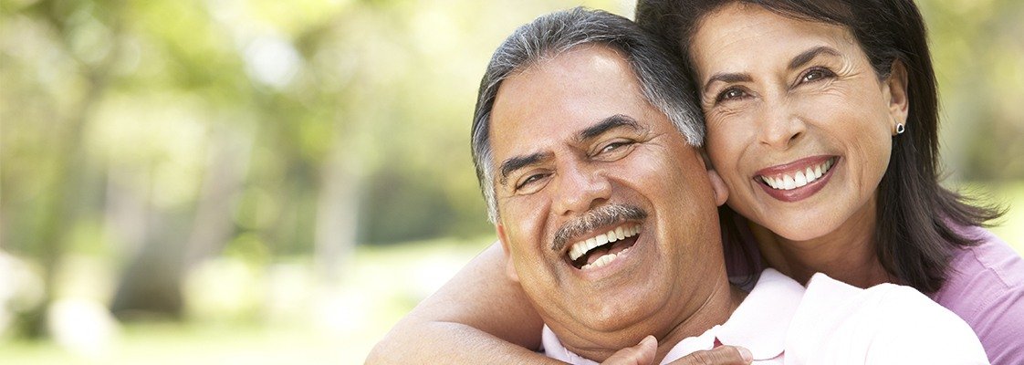 Older man and woman smiling after denture repair