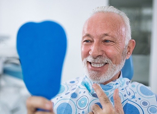 Man looking at smile in mirror