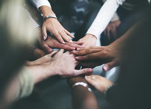 People putting hands together in circle