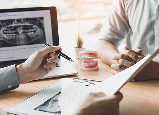 Dentist showing patient dental insurance forms