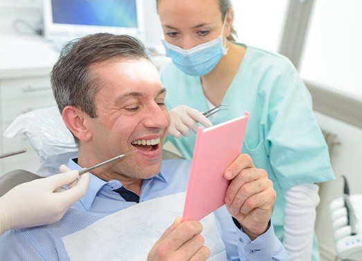 Dental patient looking at smile in mirror