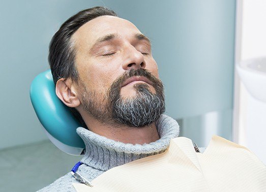 Man relaxed in dental chair under IV sedation