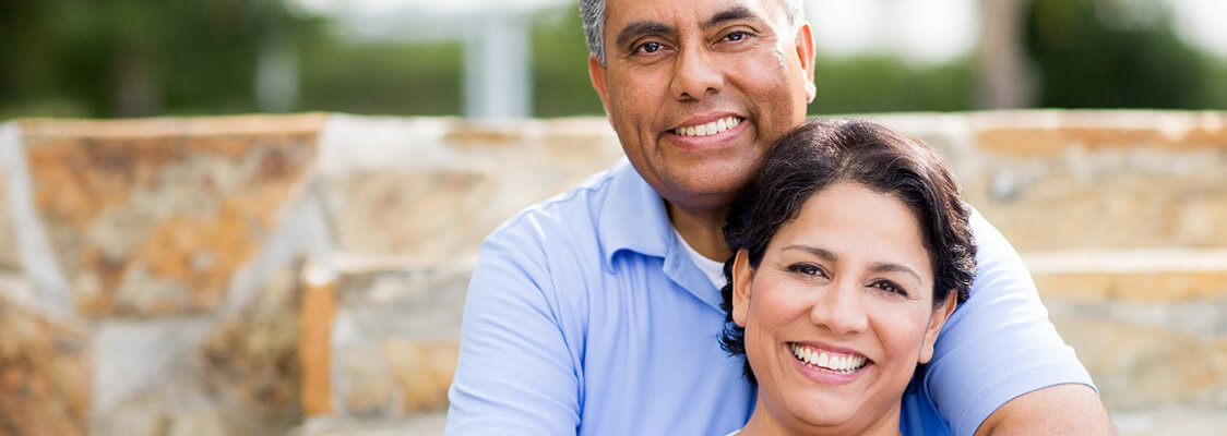 An older couple smiling outside.