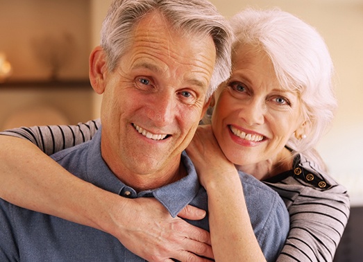 An older couple smiling and hugging.